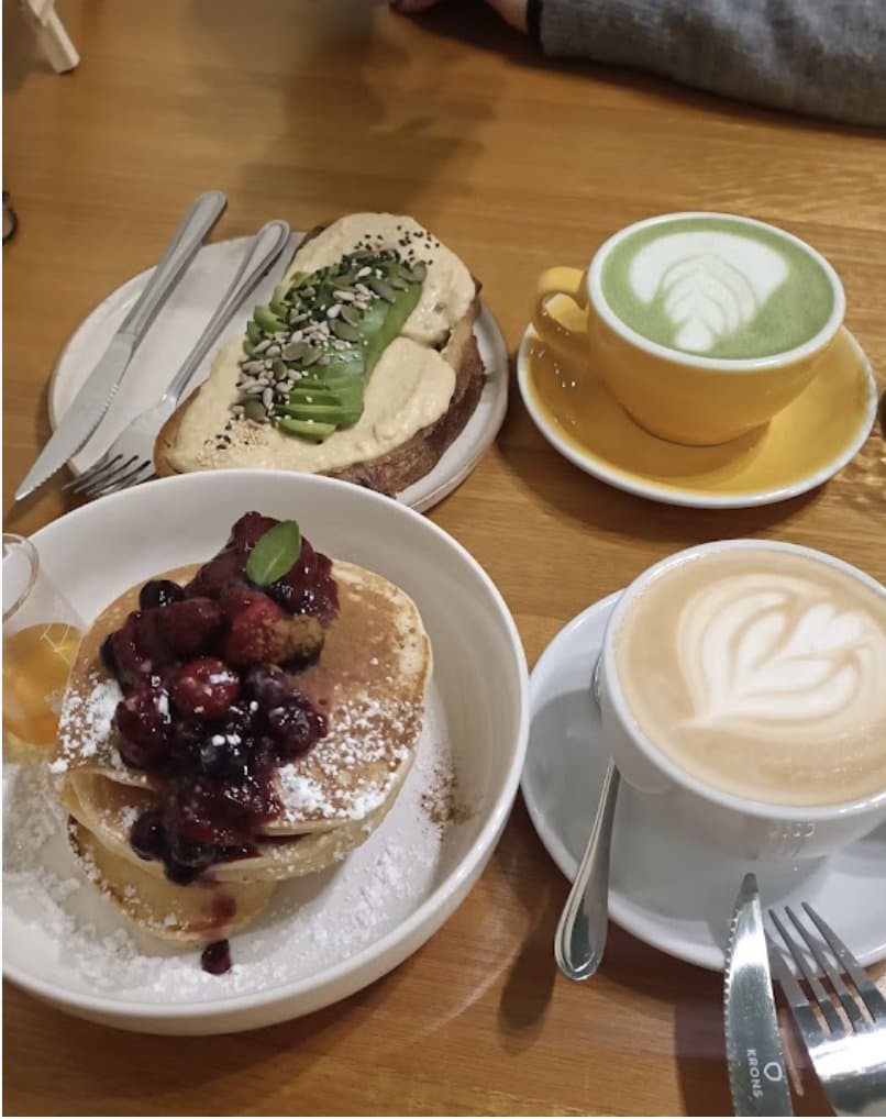Tostada de palta con matcha latte y pancakes con berries